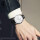 黒い腕時計に白い銀の縁がついている。